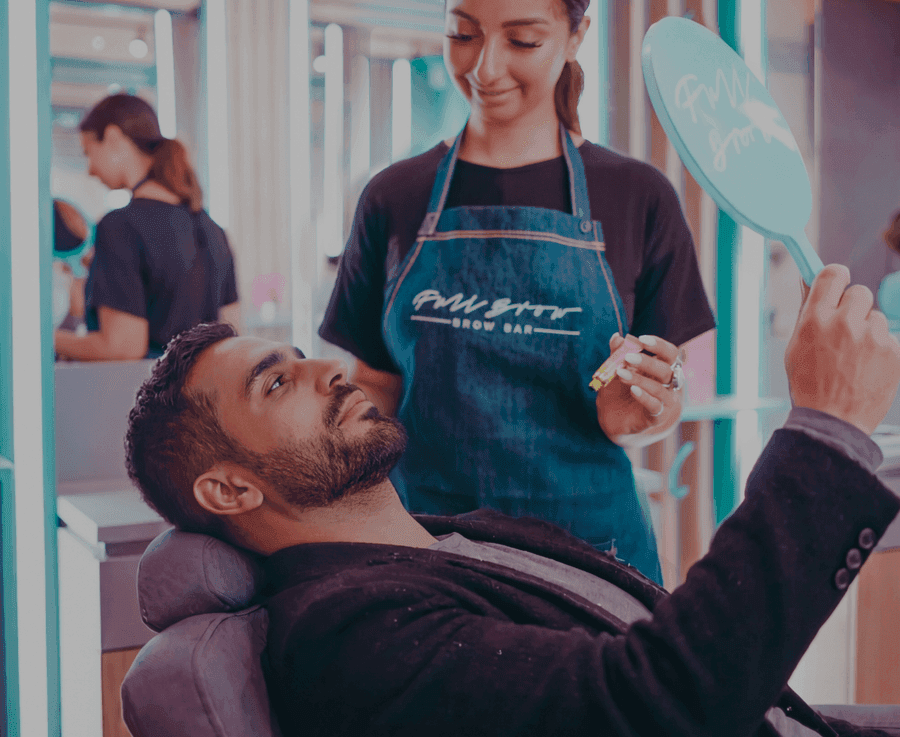 Male customer receiving brow grooming service in a Full Brow Bar studio